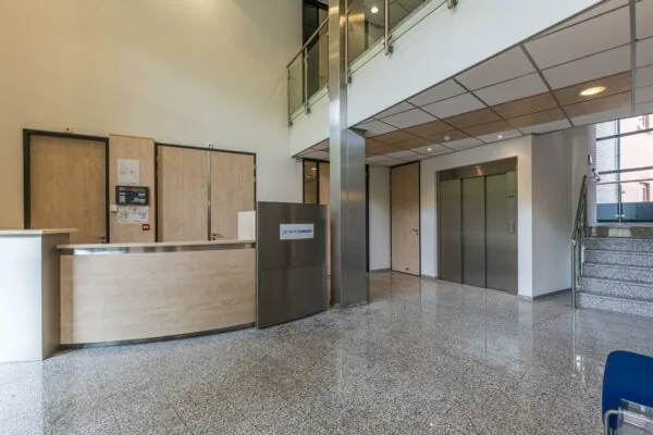 Moderne entreehal van een kantoorpand aan de Laan Blussé van Oud-Alblas met balie, lift en trap.